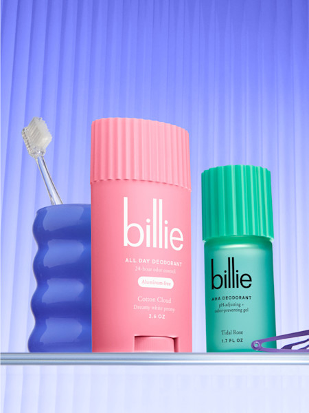 stylized tidal rose aha and cotton cloud all day deodorant next to a blue cup with a clear toothbrush and a purple hair clip