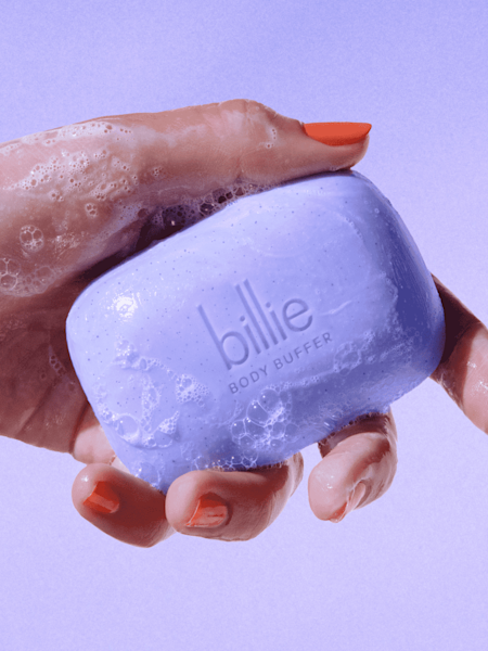 Model holding purple body buffer exfoliating bar