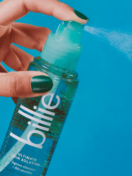 model had with green nail polish spraying the teal ultimate skin solution spray bottle