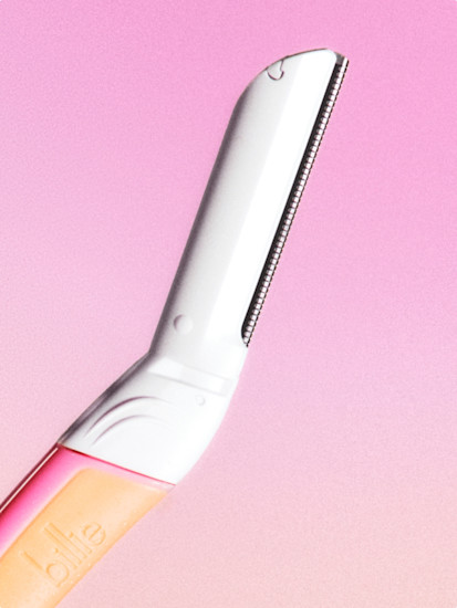 Close up of Billie Dermaplane blade on a pink gradient background